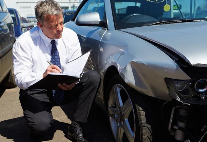 blue car with insurance paperwork and keys on a desk